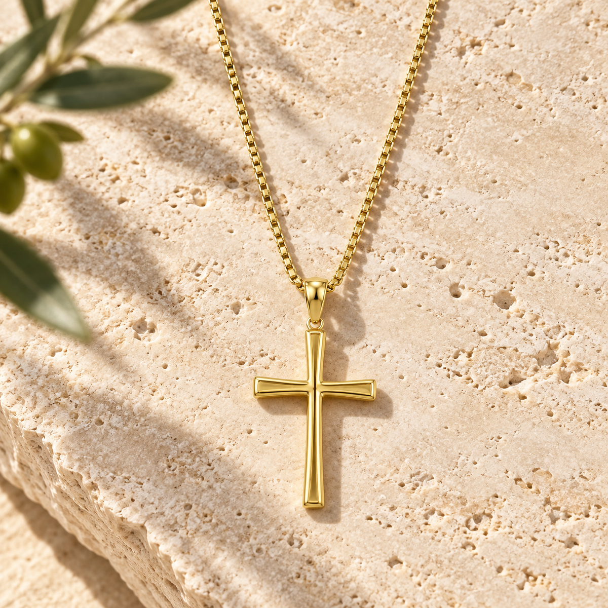 Collier Croix Épure doré – détail de la croix et de la maille sur travertin